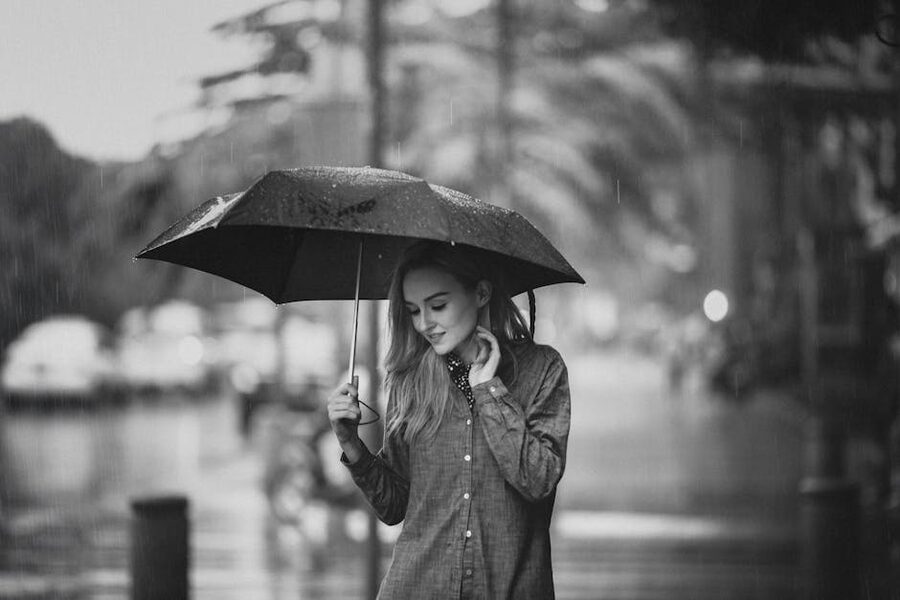Person walking on a rainy street with umbrella