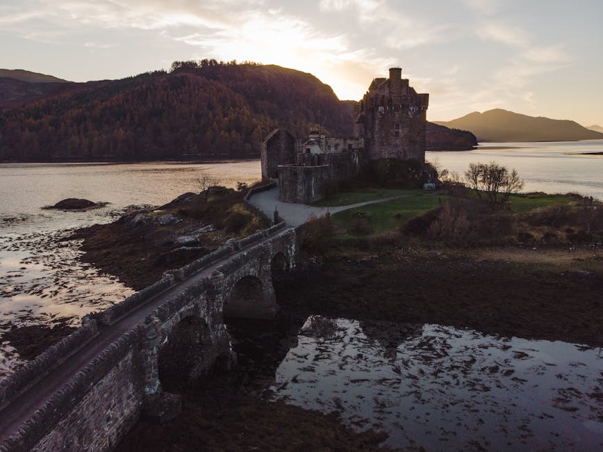Stone bridge leading to Eilean Donan Castle at sunrise