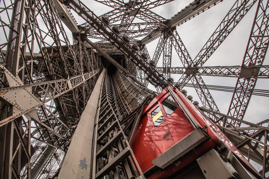 Eiffel Tower lift mechanism and ironwork against Paris sky