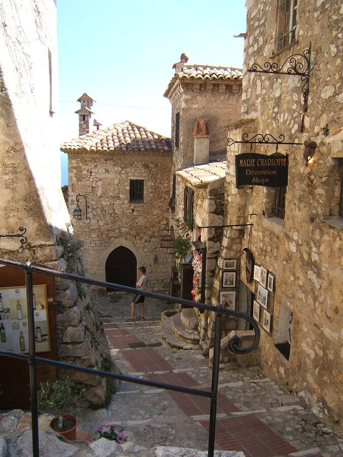 Narrow cobblestone alley in Eze village with stone walls and arched doorways