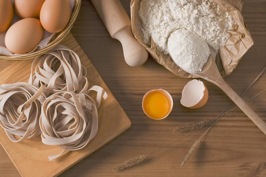 Flour, fresh eggs and fettuccine laid out for a Florence pasta class