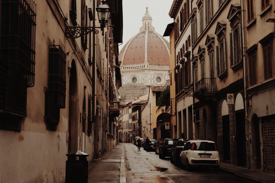 Florence street with cars and Duomo behind