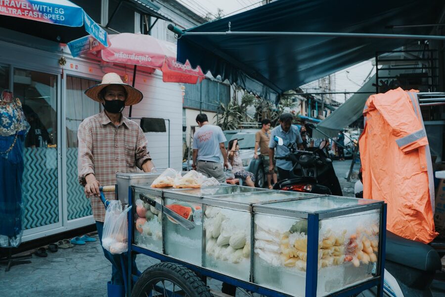Vendor selling fresh fruit from a cart at a Bangkok street market