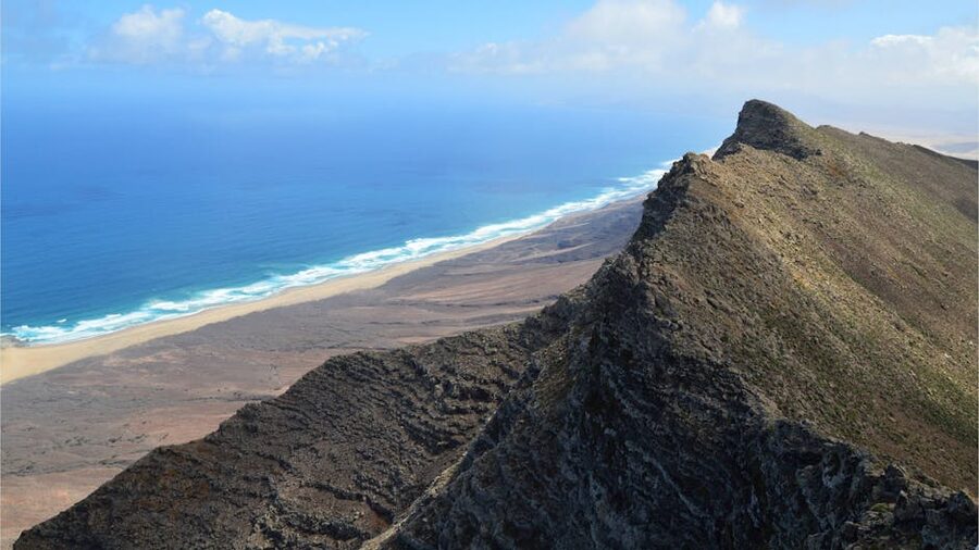 Rocky cliffs and turquoise water along the Jandia coast where snorkel stops happen