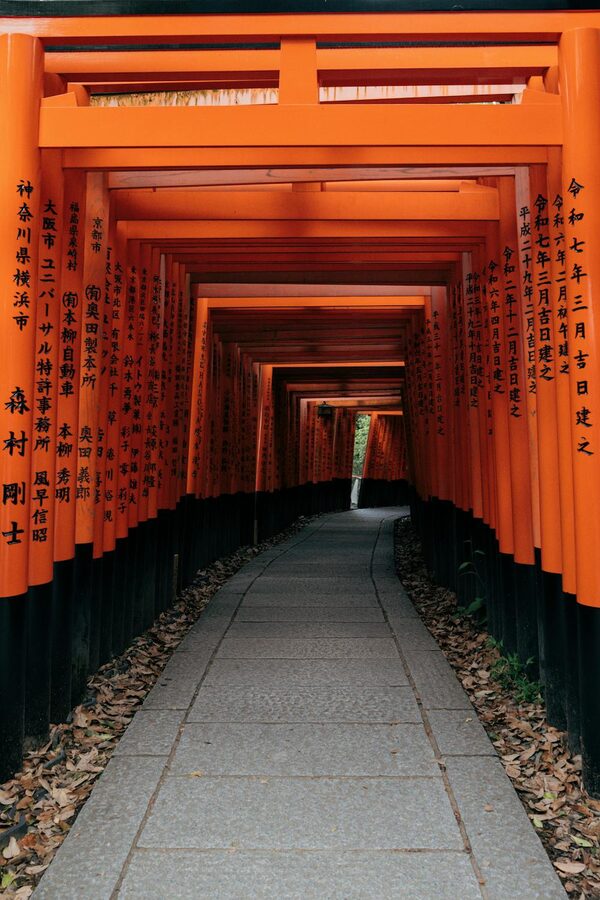 Bright vermillion torii gates creating a covered walkway at Fushimi Inari Shrine