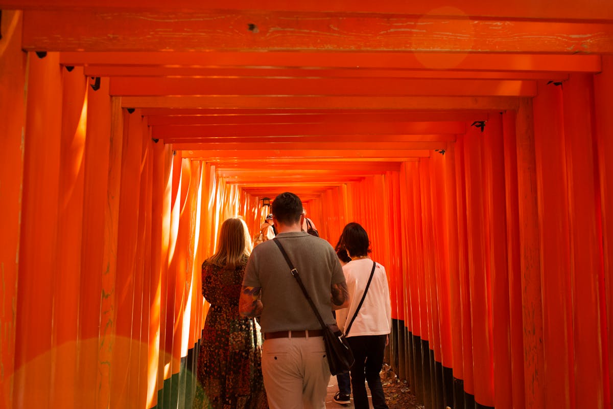 People walking through the famous torii gate path at Fushimi Inari Shrine