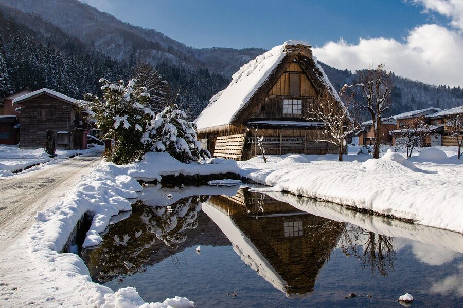 Traditional Shirakawa-go gassho-zukuri houses with their reflection in water during winter