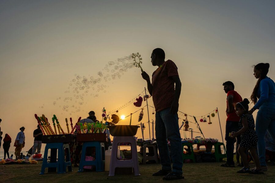 Silhouette of a bubble vendor at sunset on Galle Face Green promenade Colombo