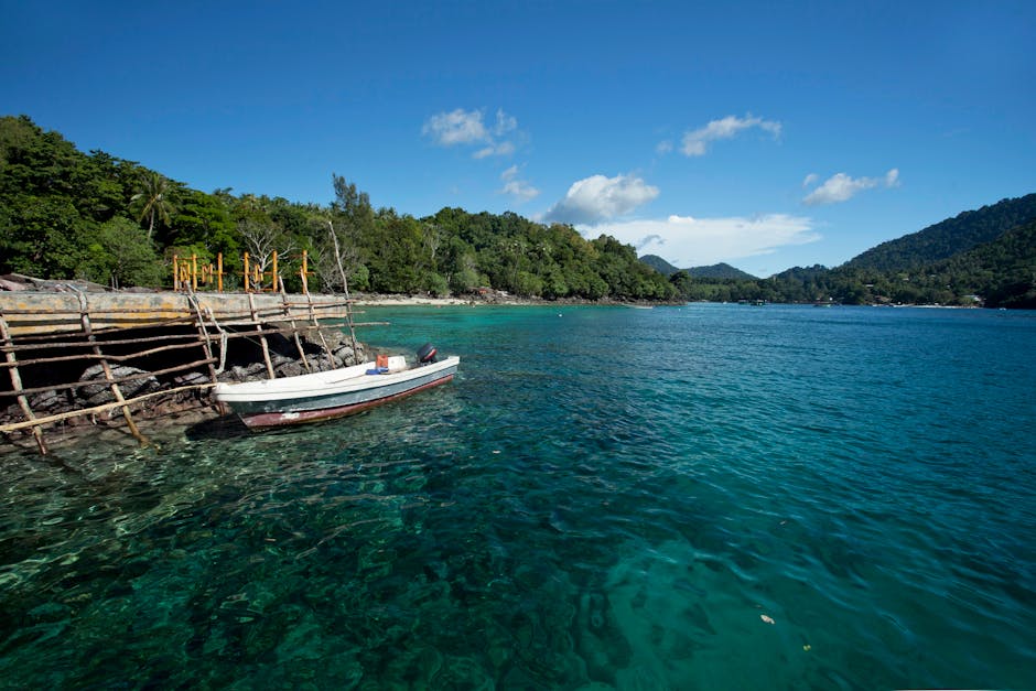 Idyllic tropical scene with a wooden boat moored in clear turquoise water