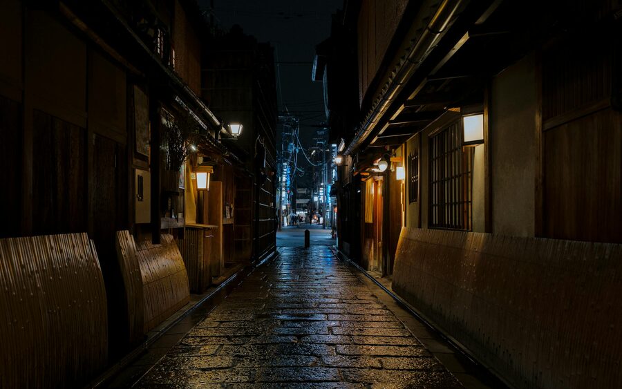 Empty traditional Gion street in Kyoto on a rainy night with reflections