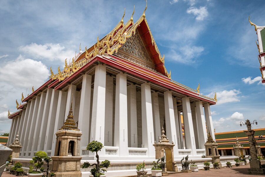 Beautiful ordination hall of Wat Pho with ornate Thai architecture under blue sky