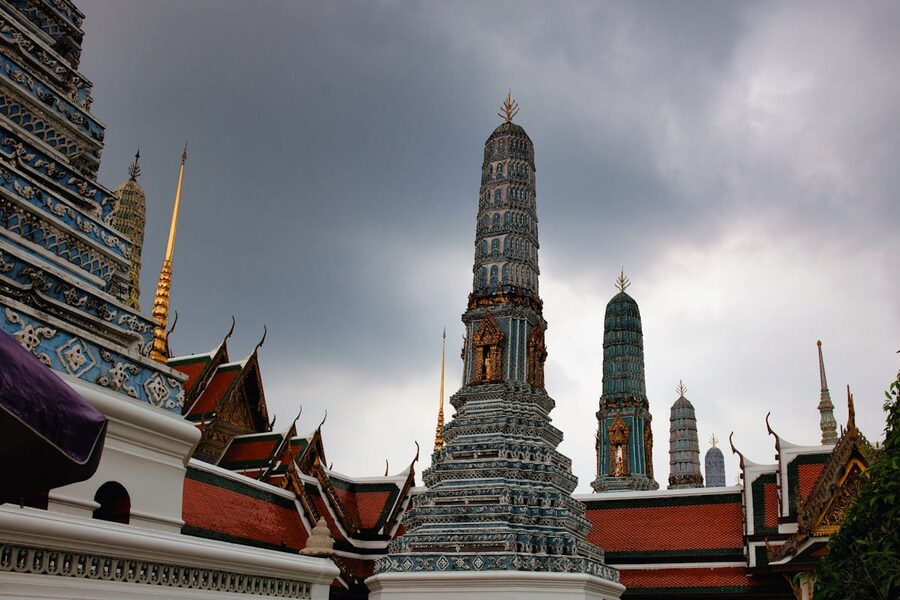 Majestic spires of Wat Arun temple against dramatic clouds in Bangkok Thailand