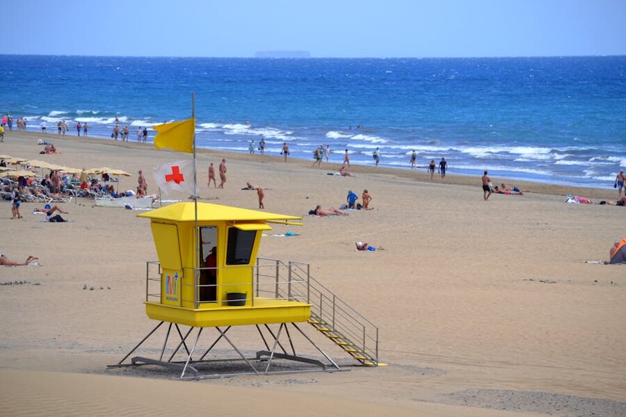 Maspalomas Beach Gran Canaria with yellow lifeguard tower and beachgoers