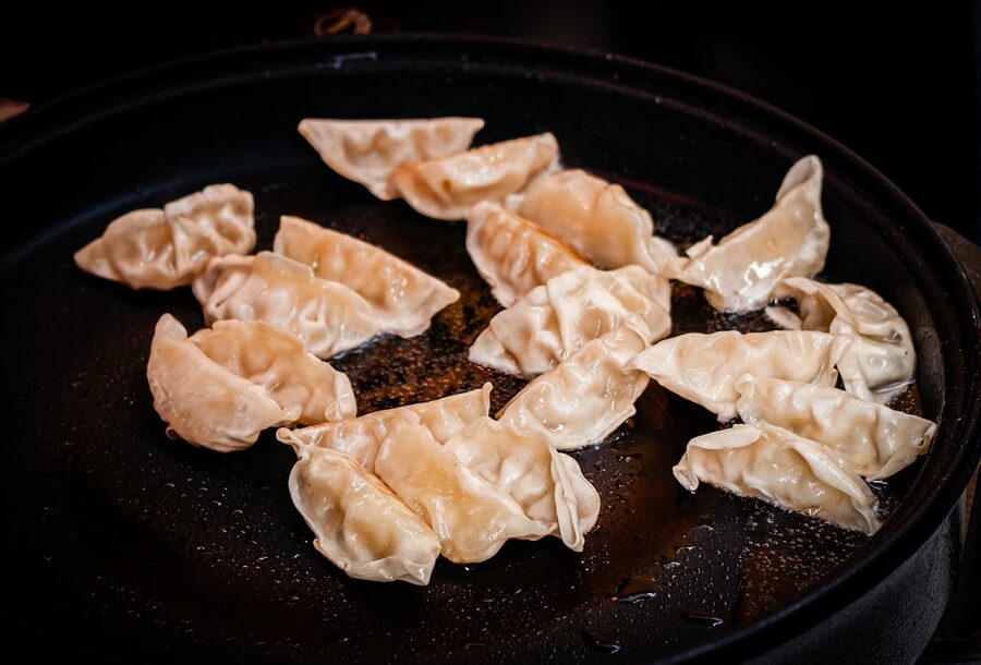 Pan-fried dumplings sizzling on a hot skillet