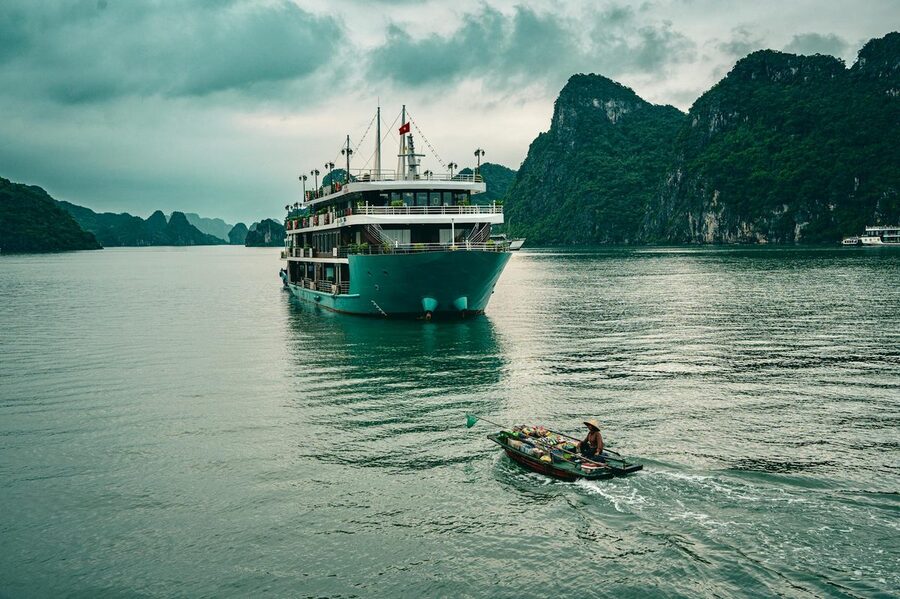 Cruise boat sailing through emerald waters of Halong Bay