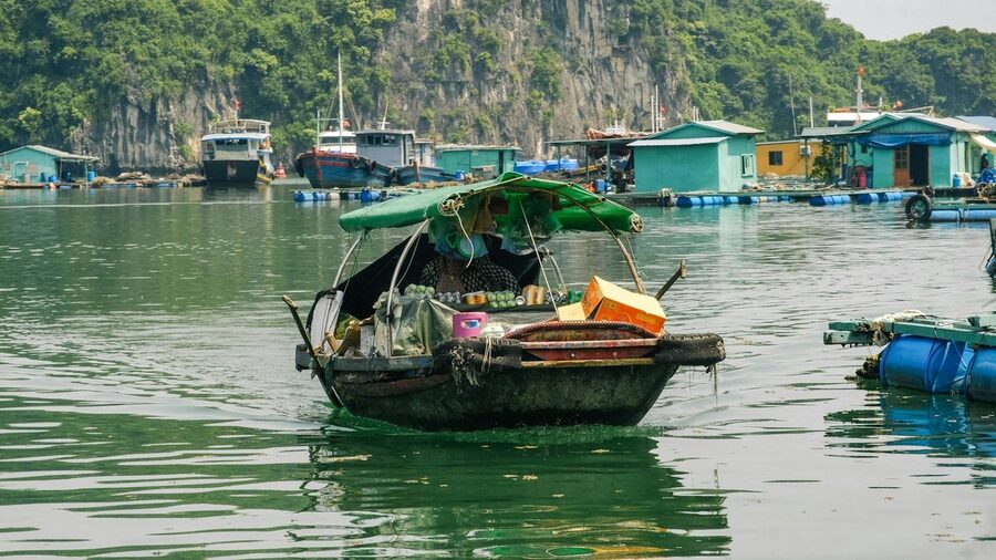 Traditional boat vendor on waters of Ha Long Bay Vietnam