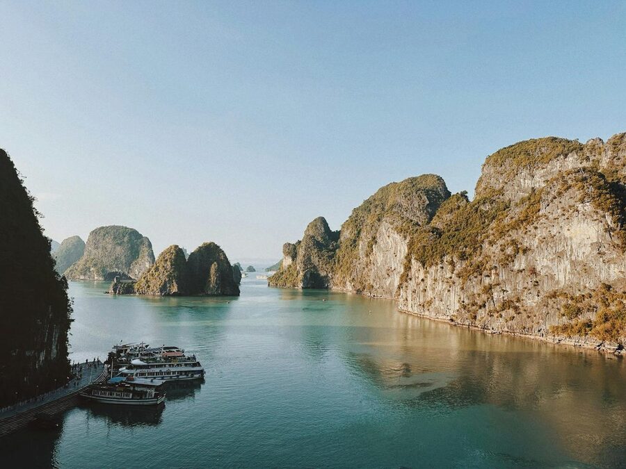 Rock formations and boats on serene waters of Halong Bay