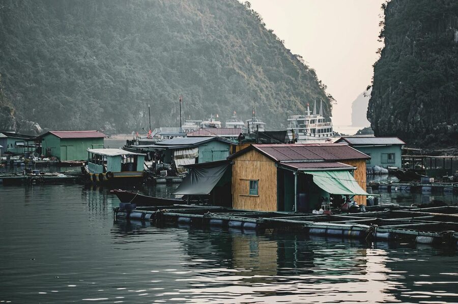 Floating fishing village surrounded by limestone formations in Ha Long Bay