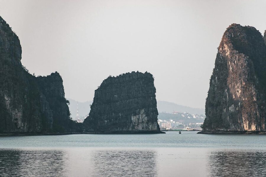 Limestone islands rising from calm waters in Halong Bay Vietnam