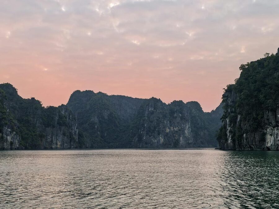Pink sunset sky over Halong Bay limestone formations