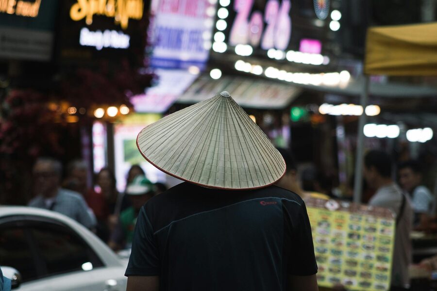 Man wearing traditional hat at Hanoi night market