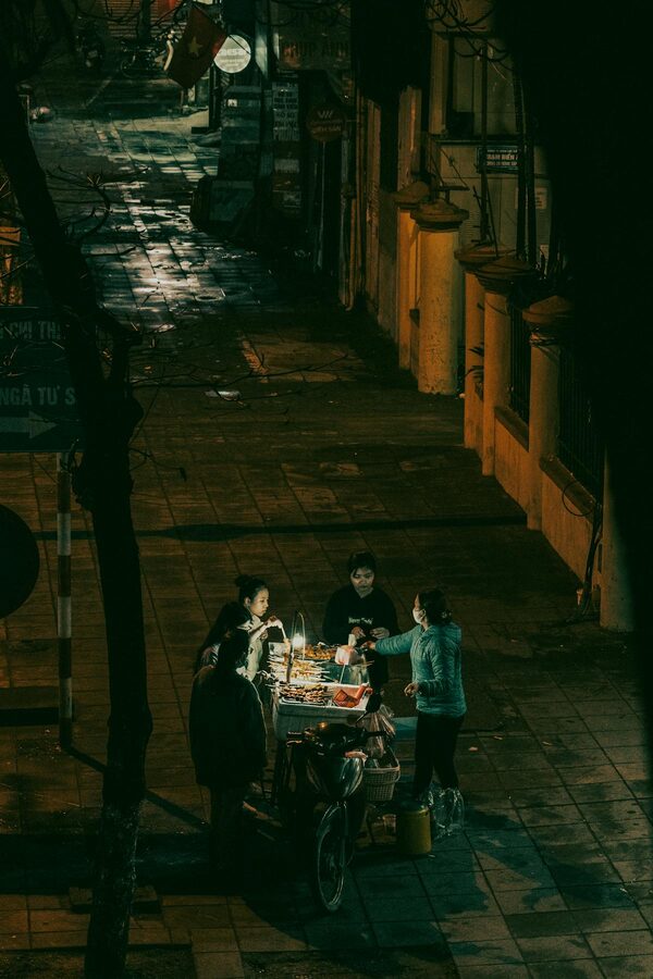 Street food vendor cooking at a sidewalk stall in Hanoi Old Quarter