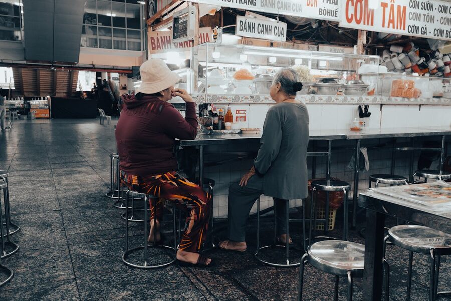 Two people enjoying a meal at a casual Vietnamese market stall