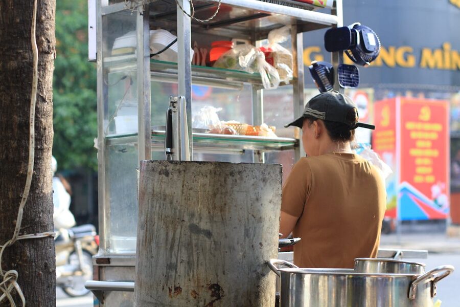 Local vendor preparing food at a street stall in Ho Chi Minh City