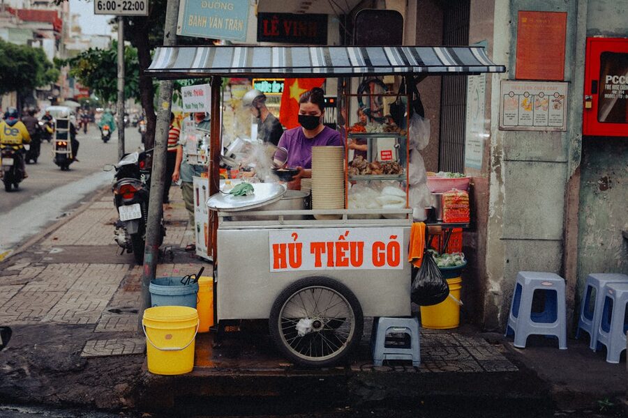 Street food vendor serving hu tieu noodles at a Ho Chi Minh City market