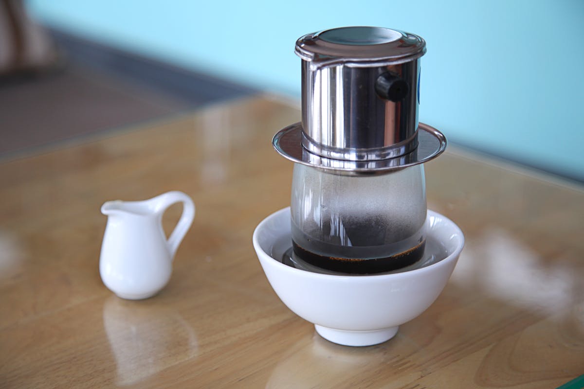 Vietnamese coffee drip filter brewing on a wooden table