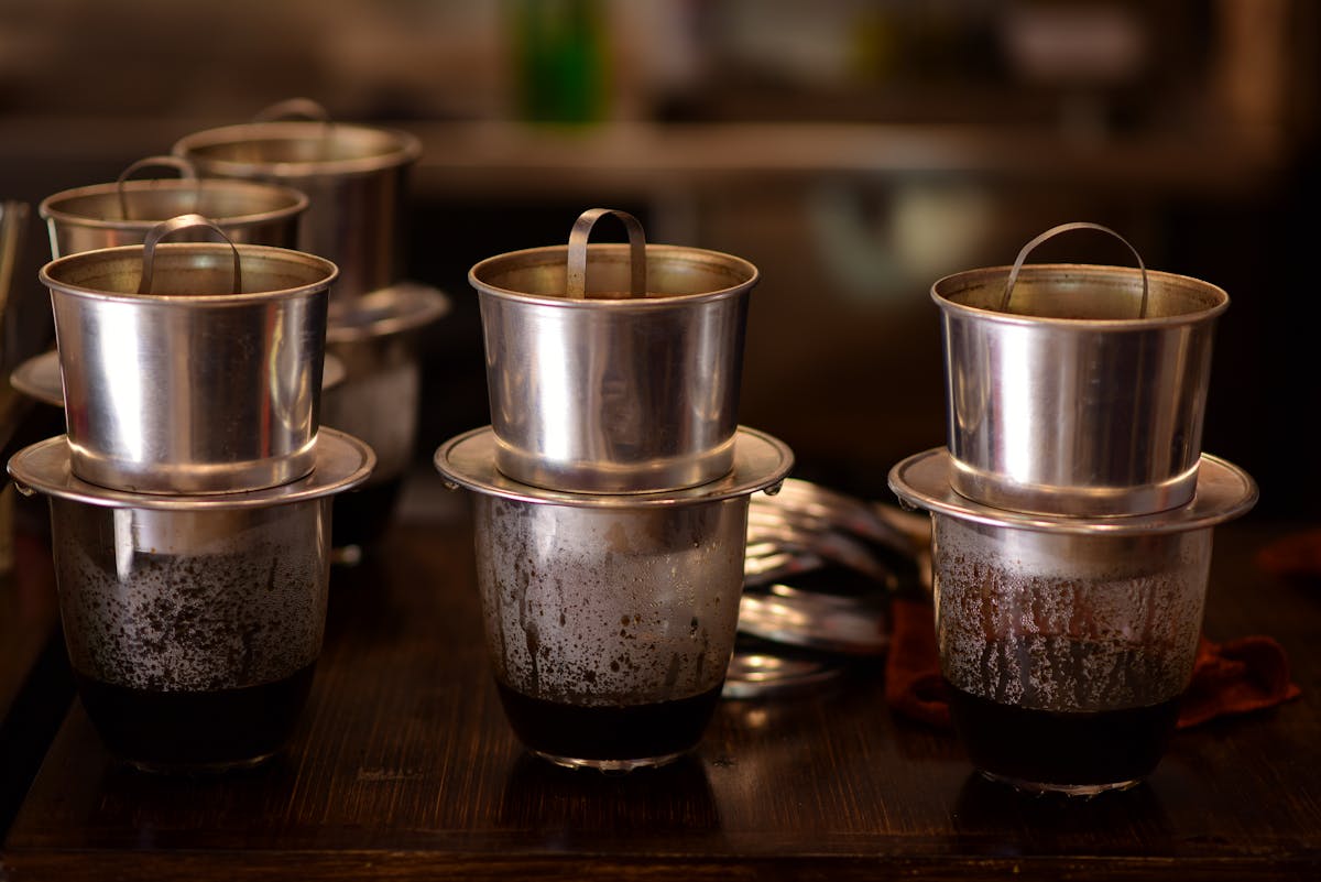 Traditional Vietnamese drip coffee makers on a wooden table