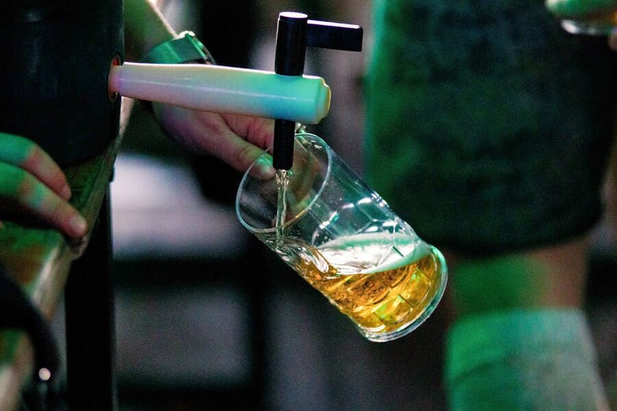 Person pouring draft beer from a tap into a glass