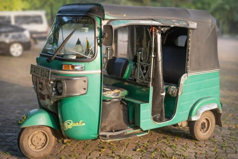 Classic green tuk-tuk parked on a cobblestone street in Colombo, Sri Lanka