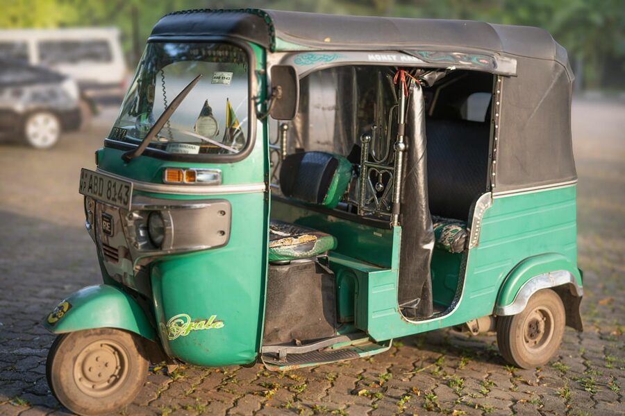 Classic green tuk-tuk parked on a cobblestone street in Colombo, Sri Lanka
