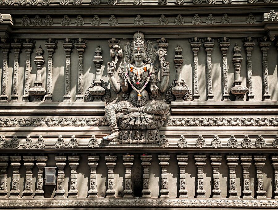 Detailed stone carving of a Hindu deity on a temple wall in Colombo