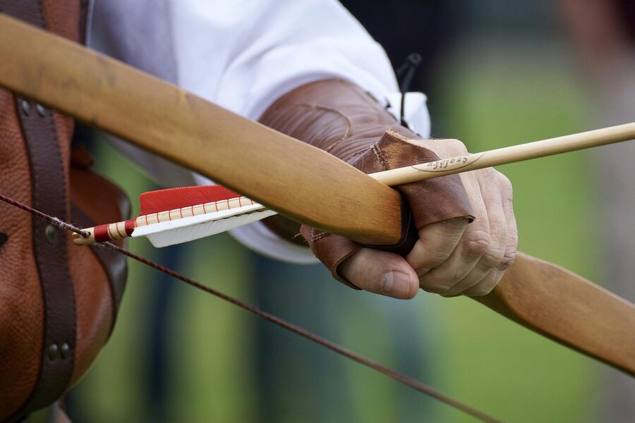 Archer at full concentration drawing a traditional bow