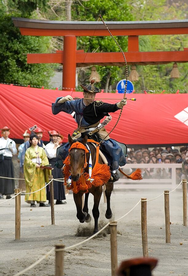 Yabusame horseback archer firing at a target during a festival