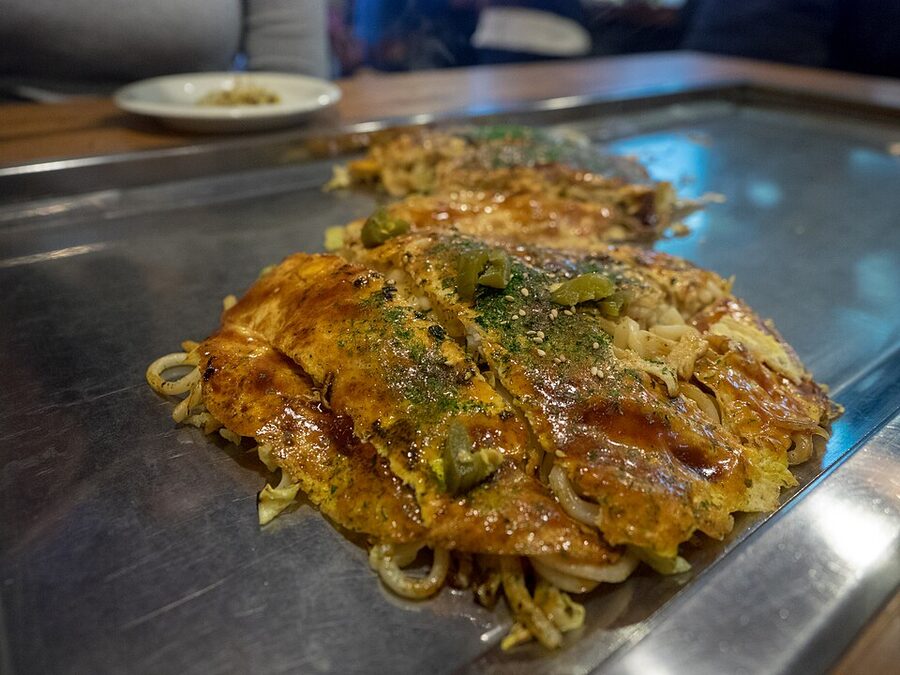 Hiroshima-style okonomiyaki layered with cabbage yakisoba noodles and fried egg