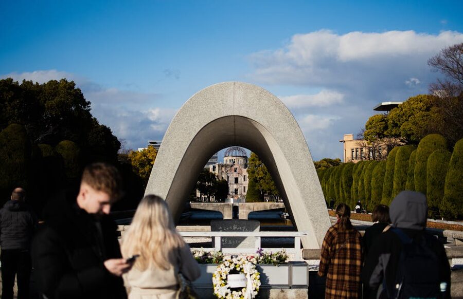 Visitors at Hiroshima Peace Memorial Park with the cenotaph arch framing the Atomic Bomb Dome