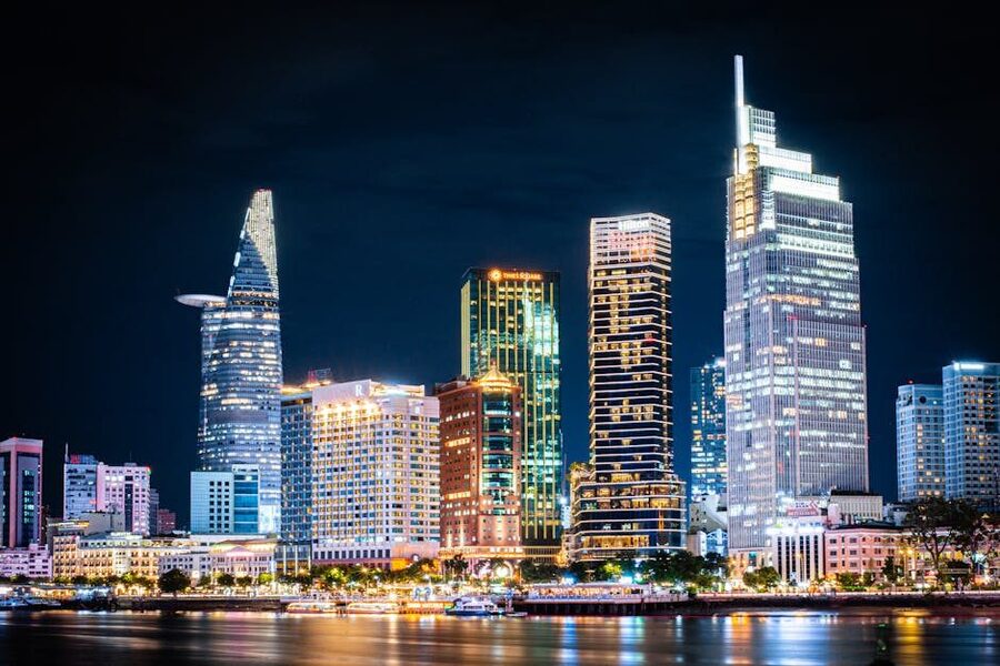 Ho Chi Minh City skyline at night with illuminated skyscrapers reflecting on water