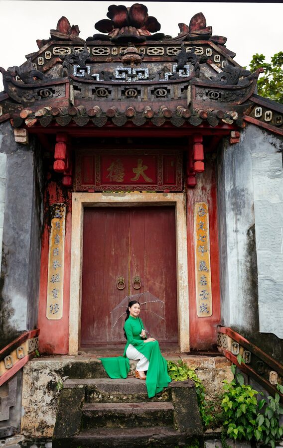 Woman in traditional ao dai at an ancient temple in Hoi An