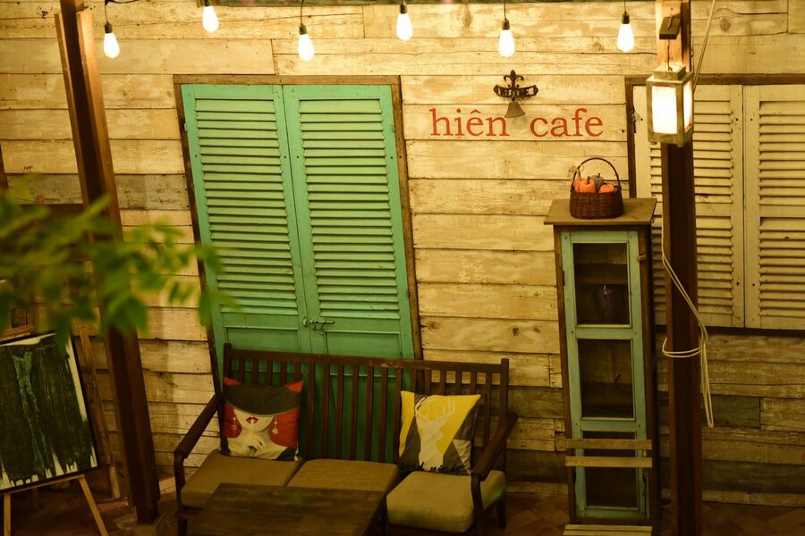 A quiet Hoi An cafe terrace with lanterns, wooden tables and morning coffee
