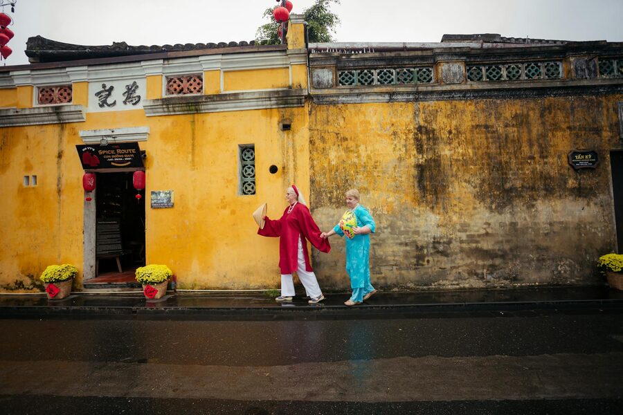 Couple walking in front of Hoi An historic yellow walls