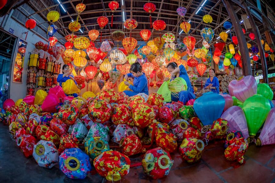 Artisans crafting and working with colorful lanterns in a Hoi An workshop