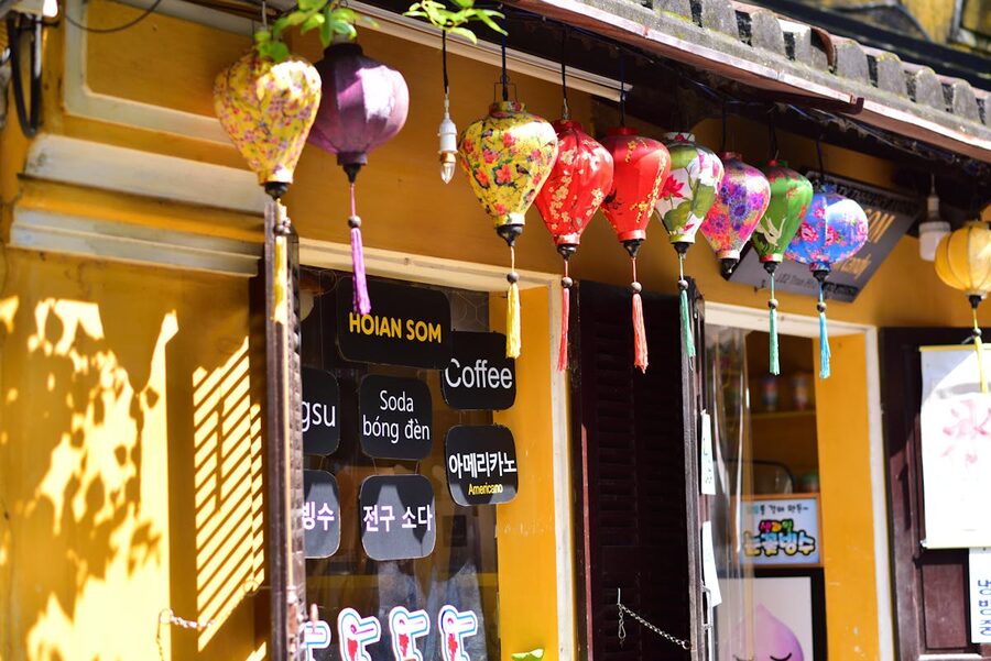 Colorful Asian lanterns hanging outside a cafe in Hoi An during daytime