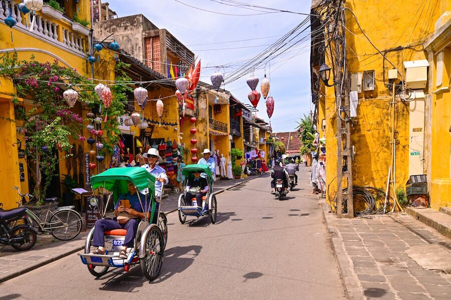 Colorful street in Hoi An with rickshaws and hanging lanterns