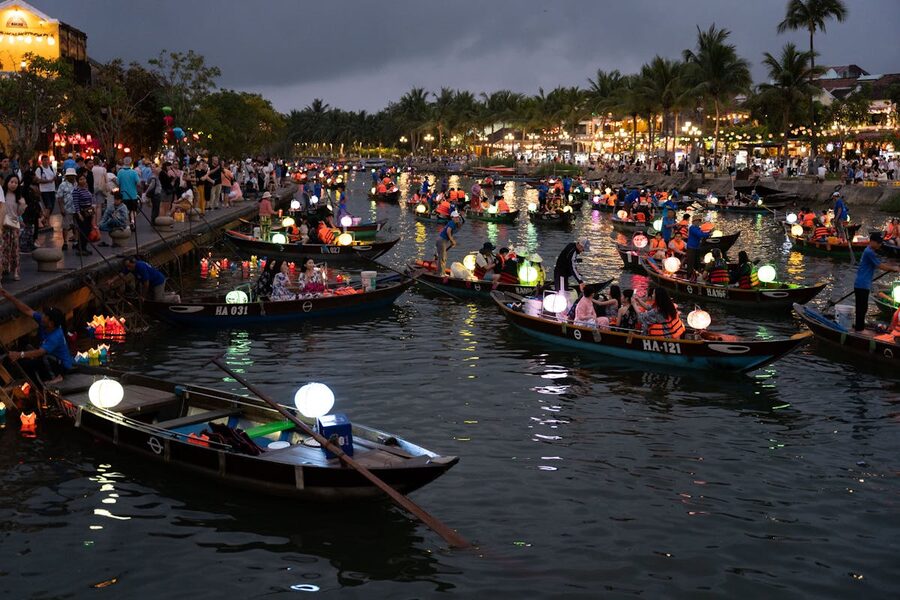 Boats filled with glowing lanterns floating on the Thu Bon River during Hoi An lantern festival