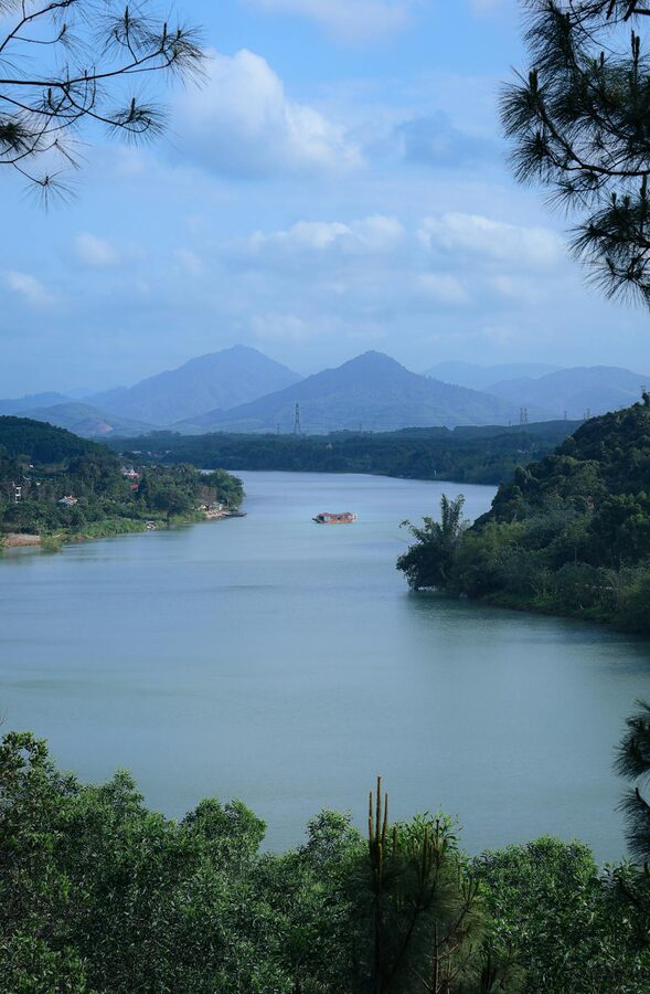 Scenic view of the Perfume River surrounded by greenery in Hue