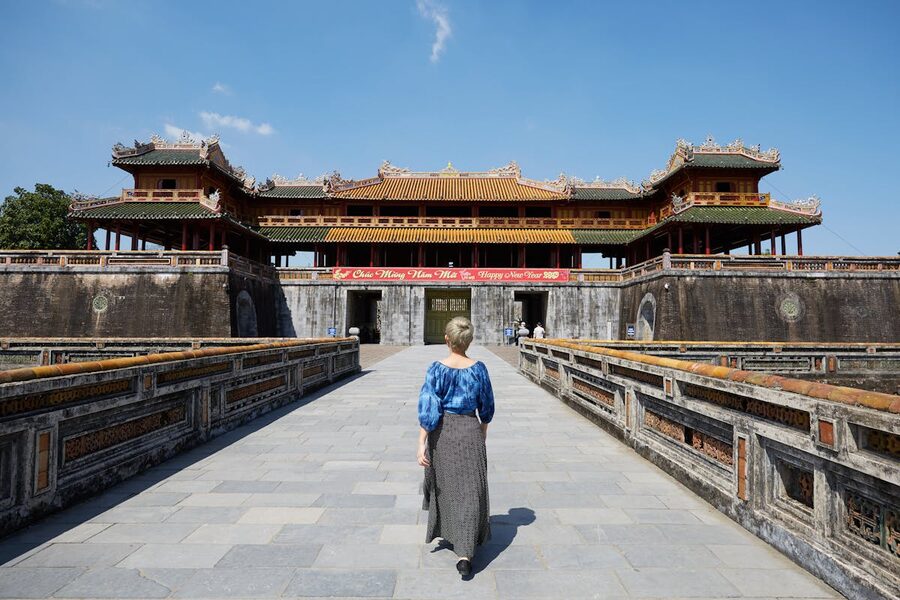 A traveler walking on a paved path near the South Gate of the Imperial City in Hue