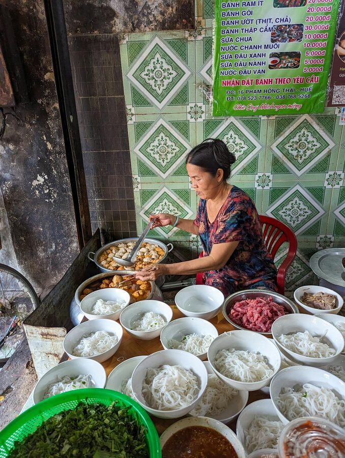 Local vendor preparing street food in Hue market